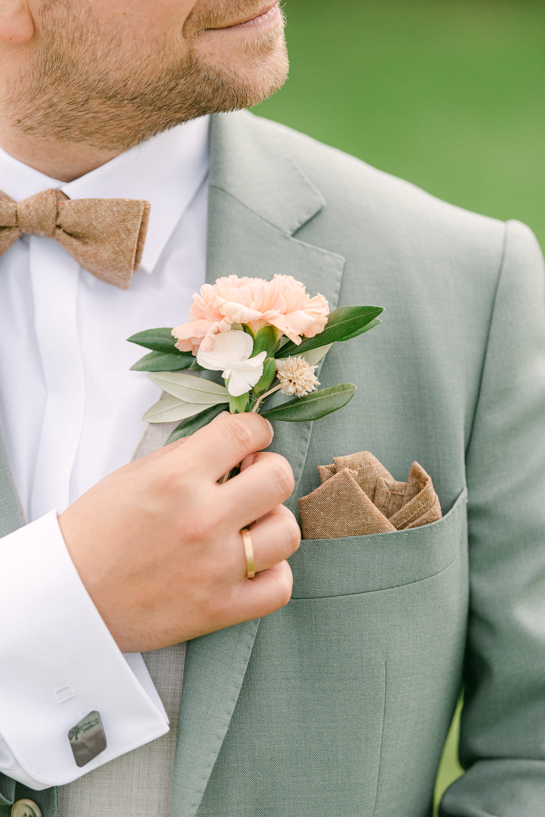 Detailfoto Braeutigam Ehering und Boutonniere Anstecker